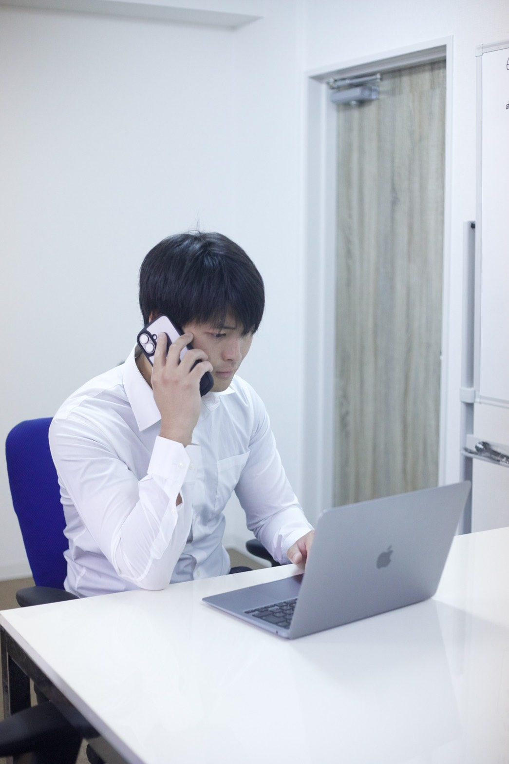 電話をしながらパソコンに向かうBLAYNのメンバー